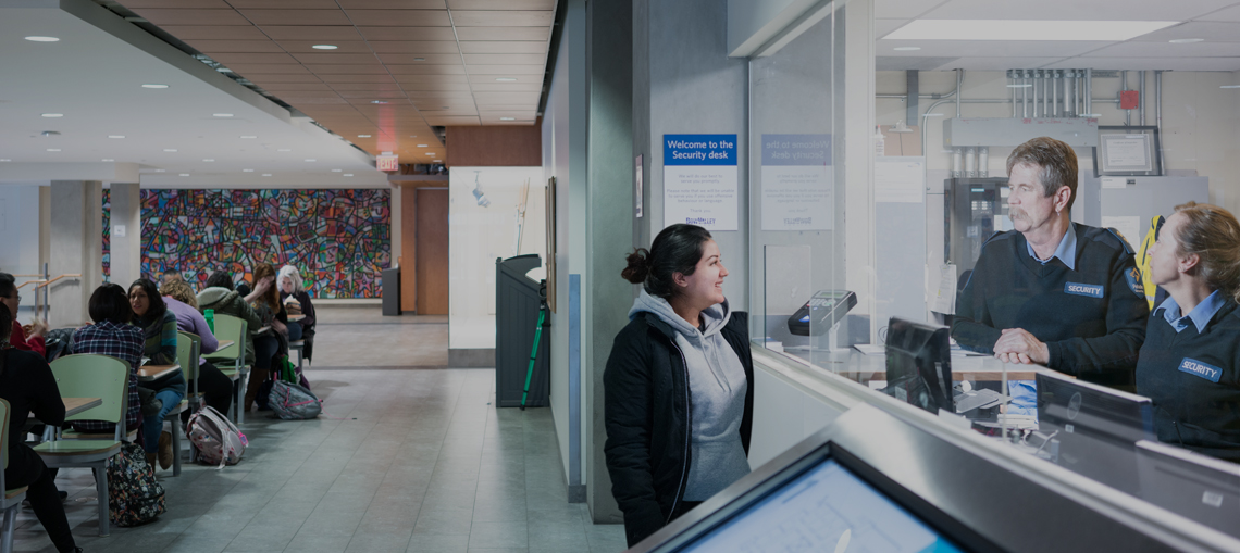 Female learner talking to security staff at Security office