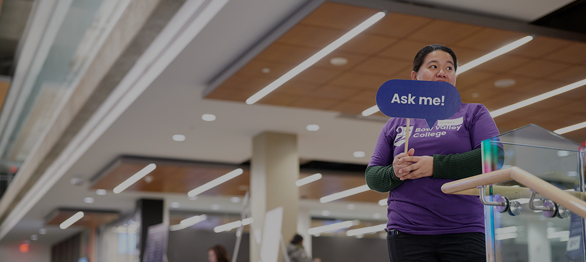 Student volunteer holding an ask me sign at NSO 2024